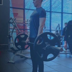 A level 3 personal training student instructs a gym user performing a deadlift