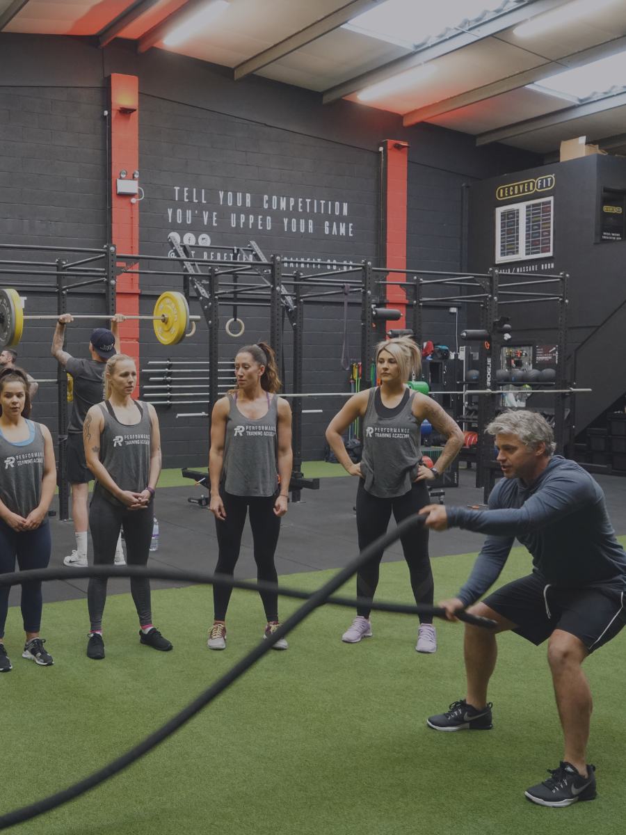 A personal trainer group training clients in a gym